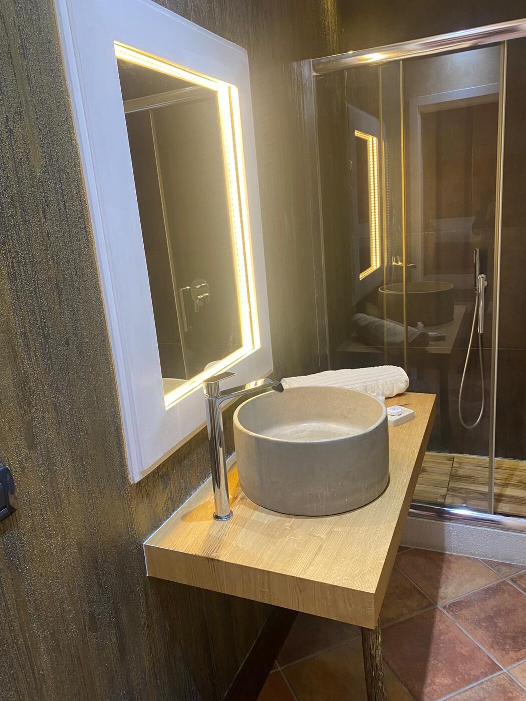 Bagno con lavabo in pietra e specchio retroilluminato