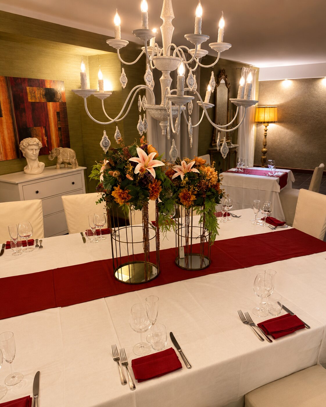 Sala elegante con candelabro, statua del David e mise en place raffinata