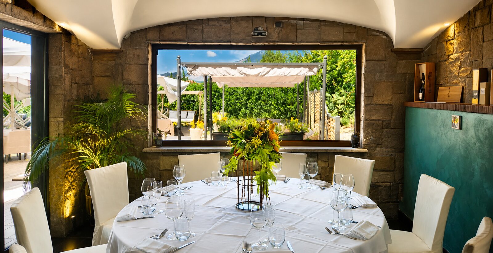 Tavolo rotondo apparecchiato con vista sul giardino