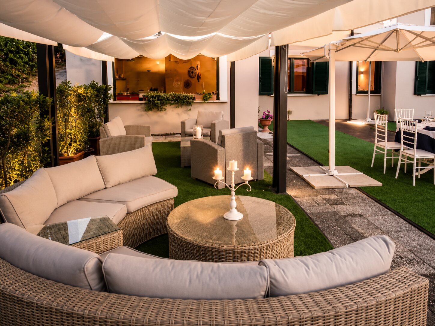 Dehors con cucina a vista e sedute lounge al calar della sera